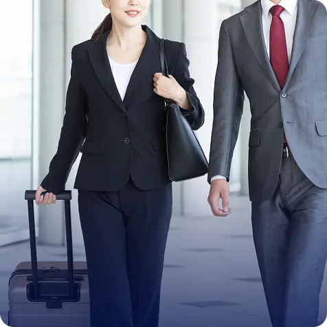 スーツケースを持って出張するビジネスパーソンの写真